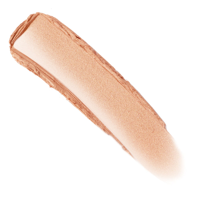 Molten Hot ColourPop Lite Stix swatch streak - creamy, shimmery peachy-gold highlighter - swept diagonally across a white background, showing blendable sheen and smooth texture.