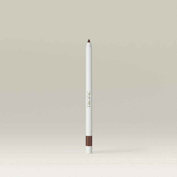 A white pencil-style eyeliner with a warm brown tip and matching brown band at the base, shown standing upright against a soft, neutral background.