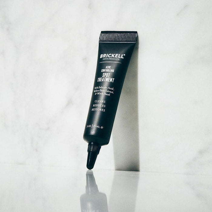 Brickell men's acne controlling spot treatment tube on marble surface with reflection