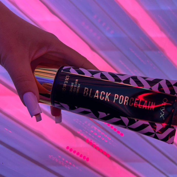 Zbliżenie dłoni z Onyx Black Porcelain. Bronzer do opalania o formule white-to-dark dla głębokiego efektu.