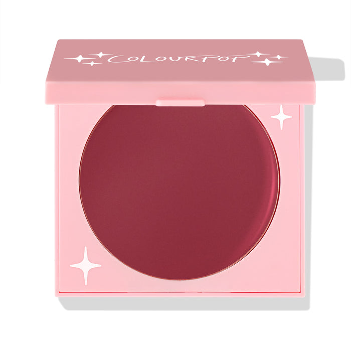 ColourPop Coyote cream blush compact sits half-open, revealing a deep berry pan in a pink square case with white star accents and ColourPop logo; matte cream formula for cheeks; ColourPop Cream Blush on a white background.