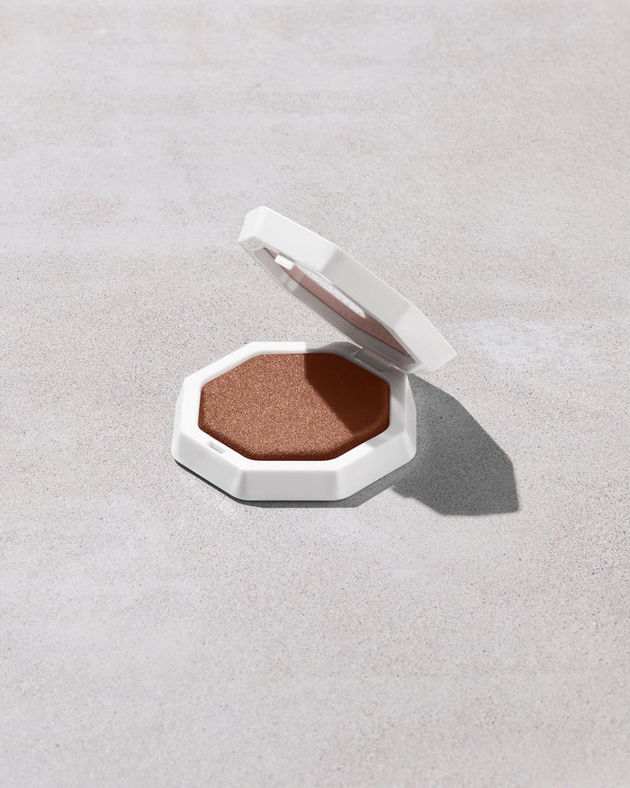 Open product shot of Demi'glow Light-Diffusing Highlighter in shade Java Jitters on a concrete backdrop.