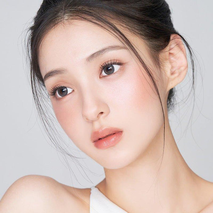 Asian model demonstrating a K-idol-inspired look with 1-Day Grey coloured contact lenses, highlighting the instant brightening and enlarging effect of the circle contact lenses over dark irises.