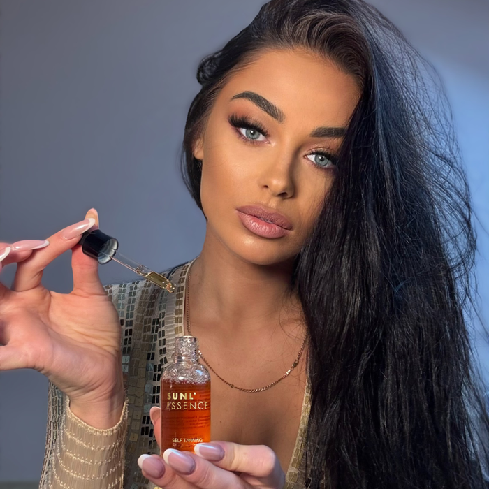 Modelka z ciemnymi włosami trzyma pipetę z kropelkami samoopalającymi Onyx Sunl’essence. Serum nadaje skórze naturalny, równy kolor opalenizny.