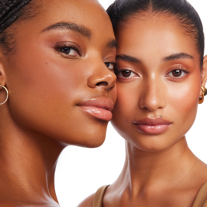 Two models showcase Moonstone Beach Bronzer Stix, sweeping creamy, buildable color across cheeks and temples for a dewy, sun-kissed glow; studio close-up highlights the radiant finish of ColourPop Bronzer Stix on two skin tones.