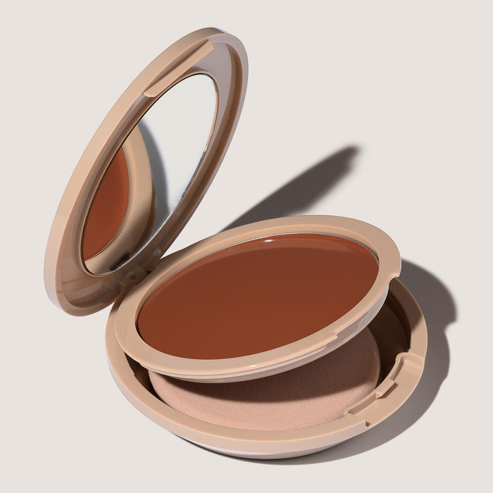 An open FlexShade Foundation by No Makeup Makeup compact in Warm Deep showing the sponge compartment