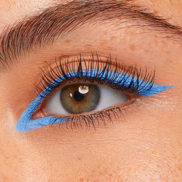 Prance ColourPop Crème Gel Liner tracing a vivid sky-blue graphic wing along the upper and lower lash lines, creating a sharp cat-eye on a close-up eye with long lashes.
