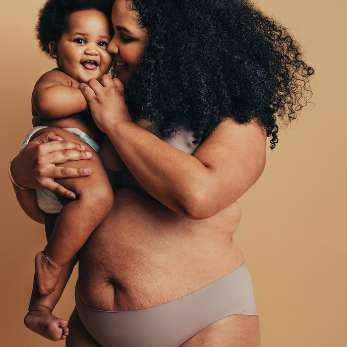 Mother embracing smiling baby, showcasing gentle skincare for all skin types and ages with natural, radiant skin texture.