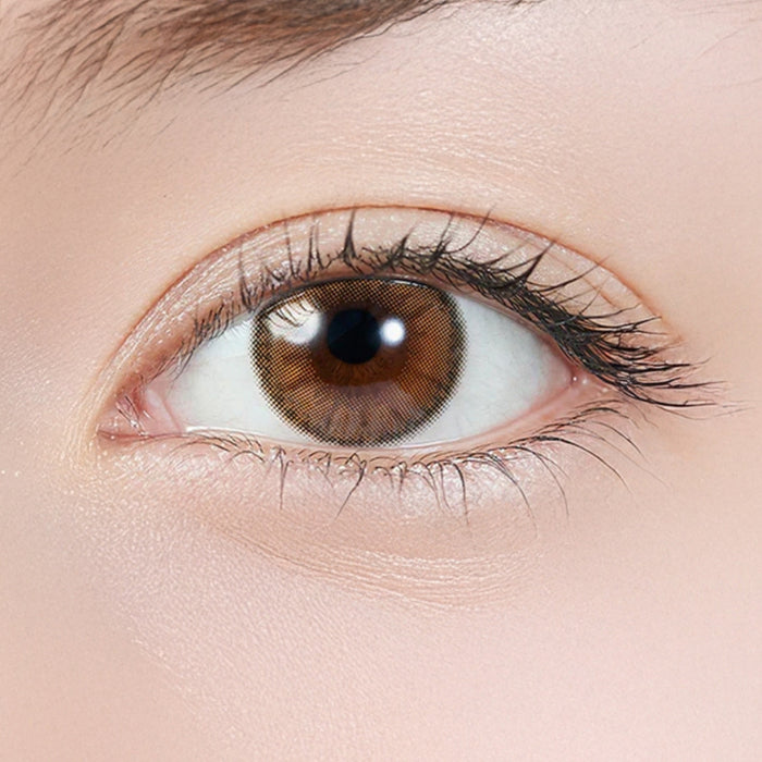 Close-up of eye wearing EyeCandys Topards 1-Day Pearl Cats Eye (10pk) prescription colored contact lens, warm beige haze over light brown iris with soft blurred outer ring, Korean daily disposable contact lens for subtle everyday eye color transformation