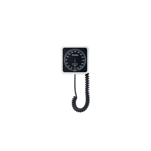 A sphygmomanometer displays a reading against a white background. The coiled cord connects to the gauge.